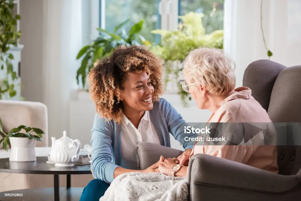 Caregiver warmly interacting with elderly patient